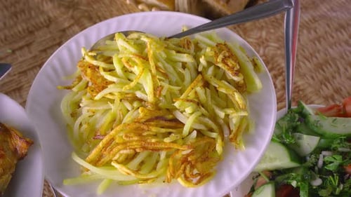 Finely grated potatoes fried in butter on white plate