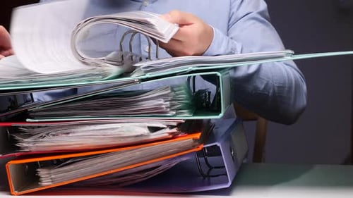 Man looks through many organized files in office