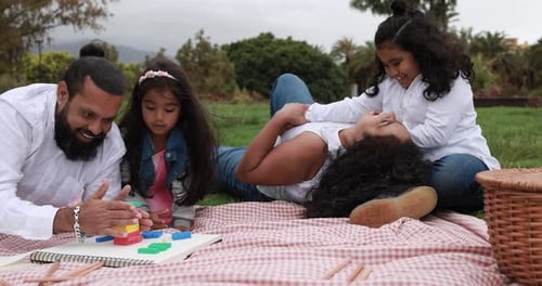 Indian Parents Having Fun at City Park Playing with Wood Toys With