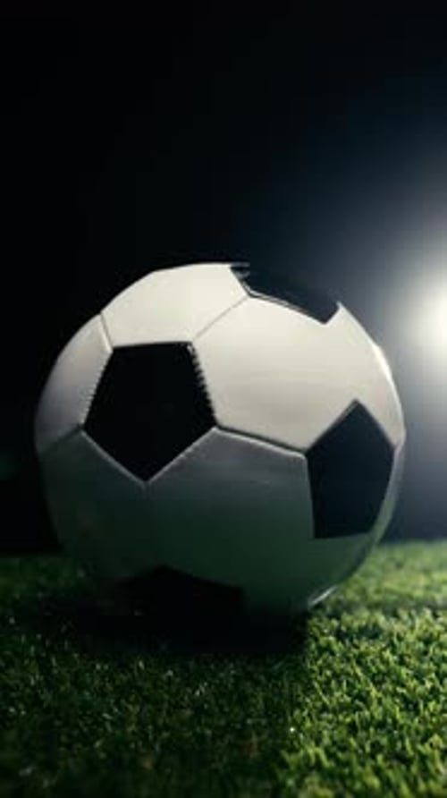 Soccer Ball Spinning on Grass in a Dark Studio