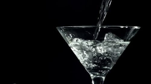 Clear Liquid Poured into Martini Glass with Ice