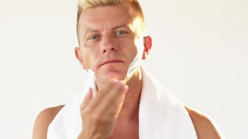 Man Applies Shaving Cream in Bright Bathroom