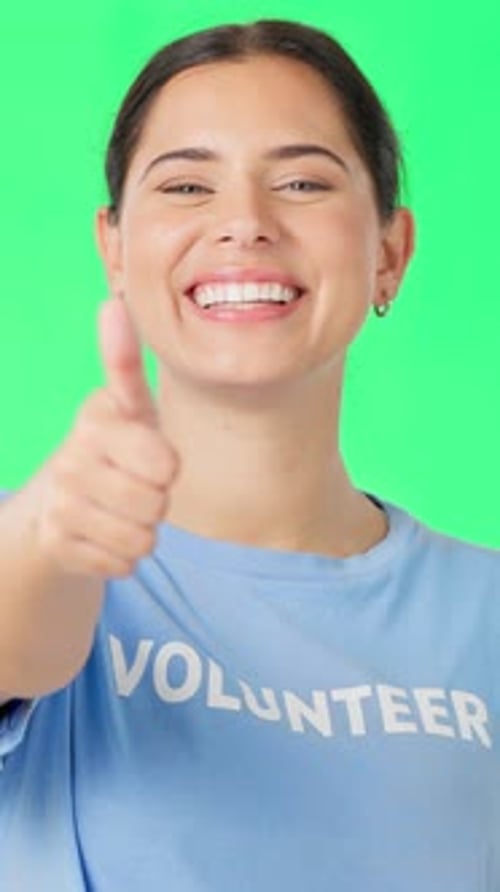 Face, volunteer and happy woman with thumbs up on green screen for non profit, thank you and goal