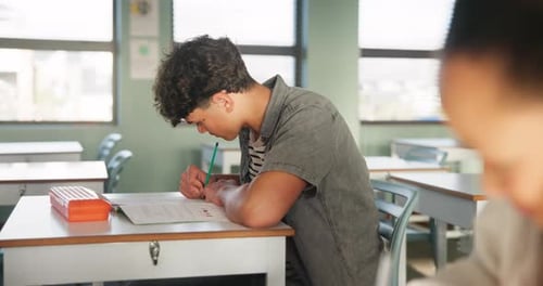 Teenage Student Completes Exam in Classroom