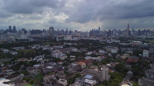 buildings of the suburb in the background cloudy sky line of the city. Spectacular aerial view fligh