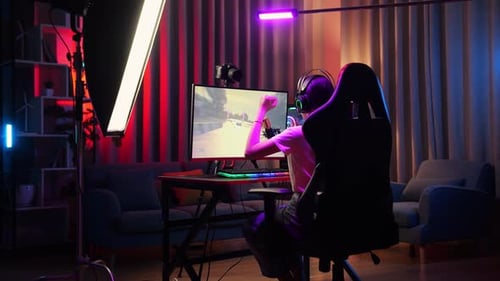 Gamer Playing Video Game in Colorful Lit Room