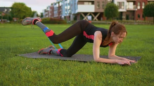 Woman Doing Leg Lifts with Resistance Band Outdoors