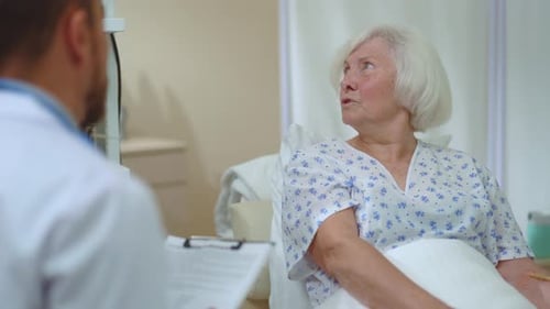 Senior Woman Talking with Medical Professional in Hospital