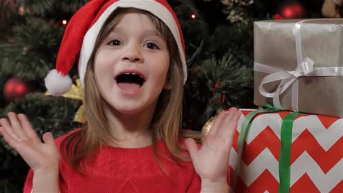 Smiling Girl in Santa Hat with Gifts