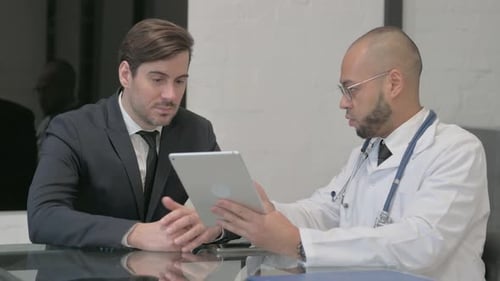 Doctor Showing Tablet to Patient in Office