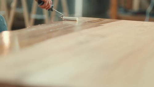 Carpenter Applying Varnish on a Wooden Table