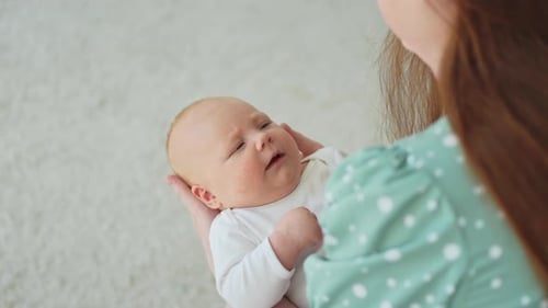 Mother Holding Newborn Baby in her Arms