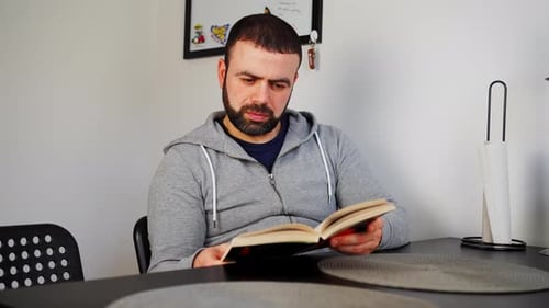 A Middle Eastern Caucasian Man Reading Book Indoors - Close Up