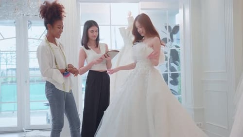 Beautiful bride discussing details with the wedding planner in studio.