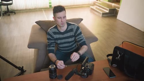 Adult Assembling Camera Equipment on Sofa Indoors