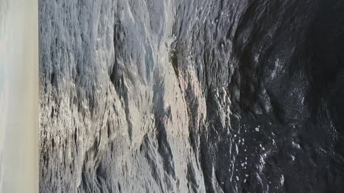 Vertical Video of the Sun Reflecting in the Waves of the Water of the Gulf of Finland at Sunset