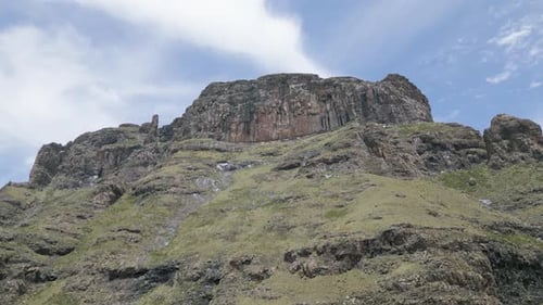 Smooth shot orbits tall rocky cliff outcrop on mountainous plateau