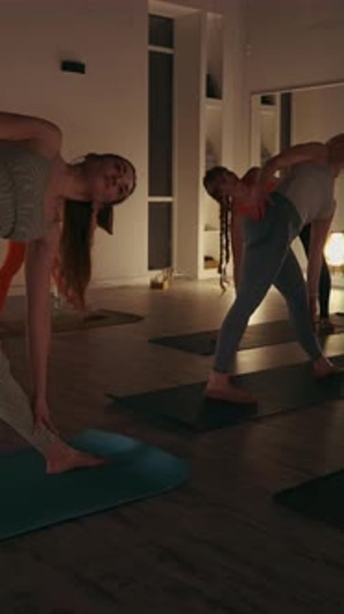 Vertical Screen Women Performing Triangle Pose in Yoga Class