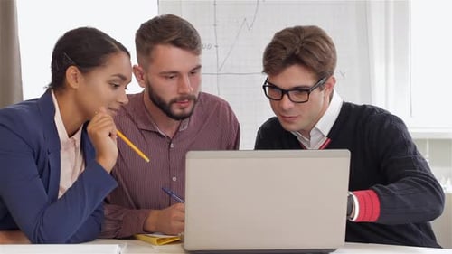 Creative Team of Two Men and One Woman Sitting at the Office