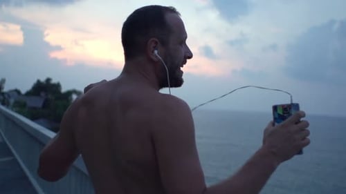 Happy Man Dancing While Listening to Music on Terrace, Super