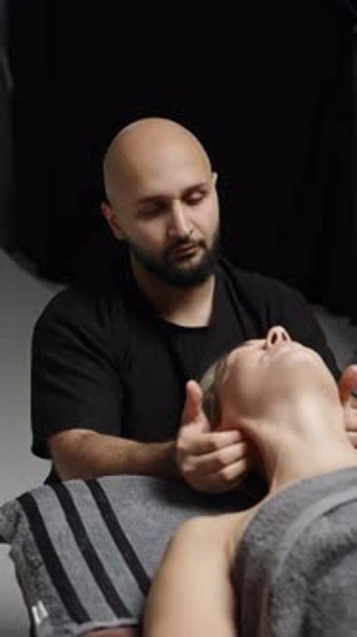 Therapist Performs Gentle Neck and Head Massage on Relaxed Client Showcasing Skilled Manual Bodywork