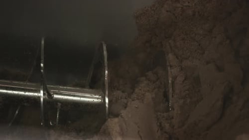 Auger conveyor mixing malt in brewery