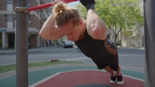 Strong Man Exercising at Outdoor Gym in the City
