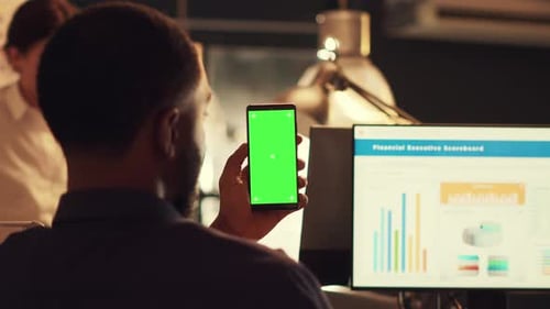 Man Holds Phone With Green Screen at Office