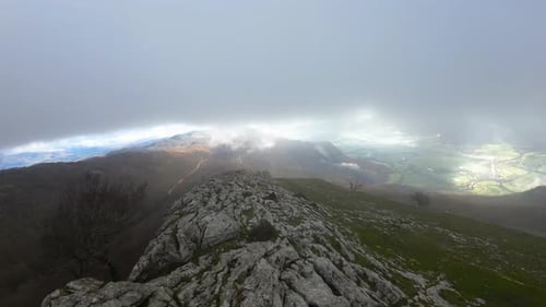 Drohne, die über den Gipfel eines grauen Berges fliegt. Sehr steinig. Ein Tag mit Nebel. Monte San Miguel de Aralar