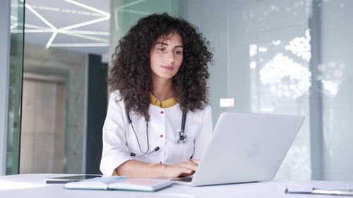 Female Doctor Working on Laptop in Hospital Office