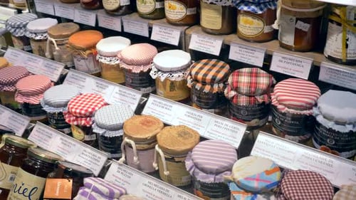 Exhibición de varios sabores de mermelada casera en pequeños frascos de vidrio.