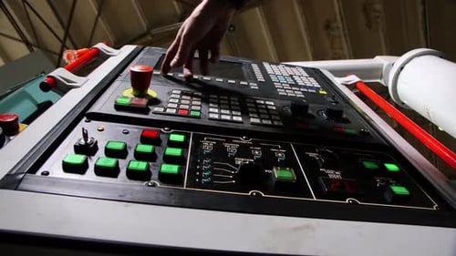 Employee Presses Different Keys to Program Machine Tool