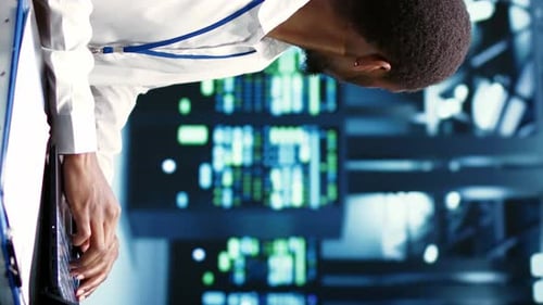 Man Coding Software on Laptop at Night