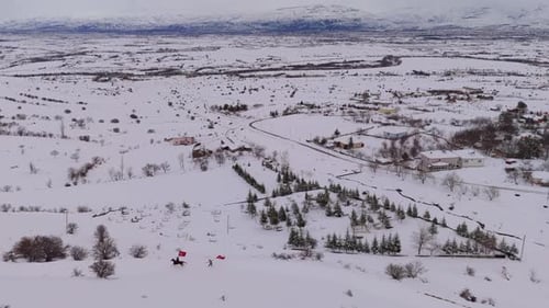 Horseback Rider and Man with Flag in Snowy Landscape