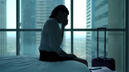 Young Businesswoman Having Head Pain While Sitting on Bed in Hotel Room 30s