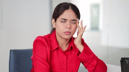 Businesswoman Massaging Temples to Relieve a Headache