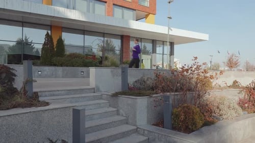 Woman jogging down steps outside modern building