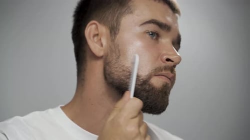 Man Combs His Beard