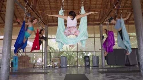 Mulheres felizes em pose estendida de sereia na aula de ioga aérea Shot em câmera lenta
