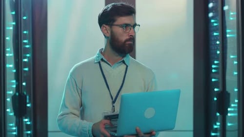 Technician Holding Laptop in Server Room