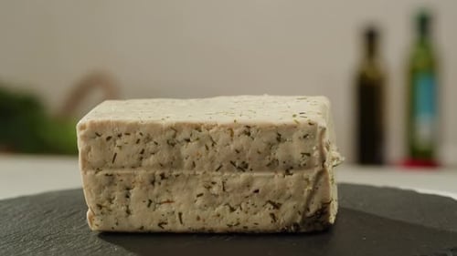 Fromage découpé par le chef pour tofu frit avec graines de sésame et épices sur une poêle en fonte pour la cuisson d'une salade japonaise