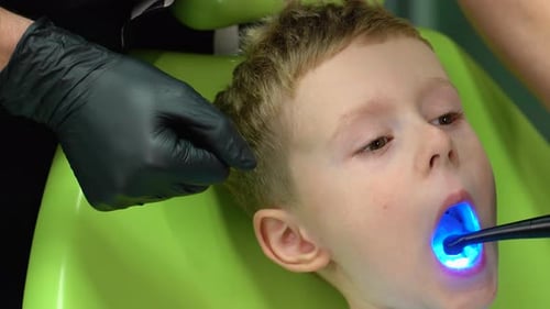 Child Receiving Dental Exam with Blue Light