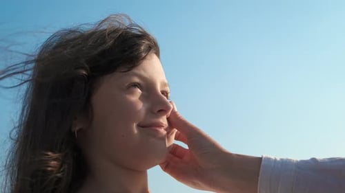 Gentle Touch: Adult's Hand Pokes Child's Nose Affectionately
