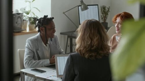 Women Collaborate on Project in Modern Office