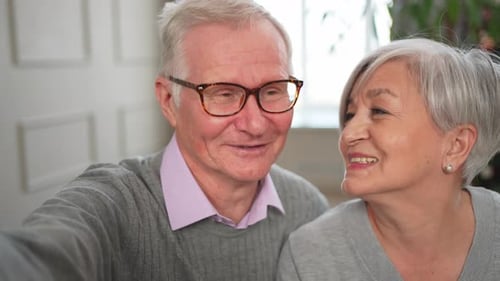 Smiling Senior Couple Video Calling in their Home