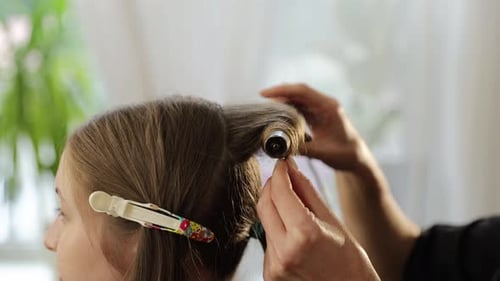 Ein erfahrener Profi zeigt künstlerisch, wie man Haare mit einem Lockenstab effektiv lockt