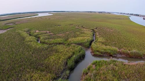 Drone footage of Charleston marshlands showing winding creeks through green wetlands and tidal