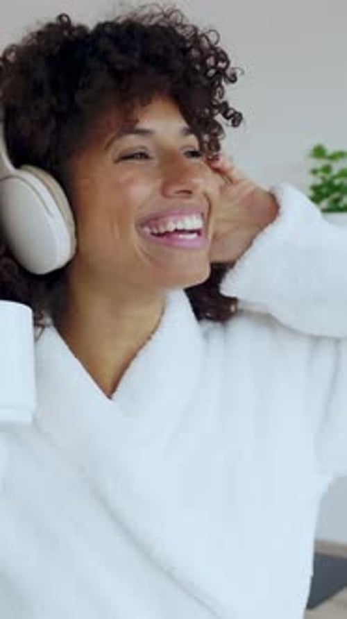 Smiling Woman Listening to Music in Bathrobe
