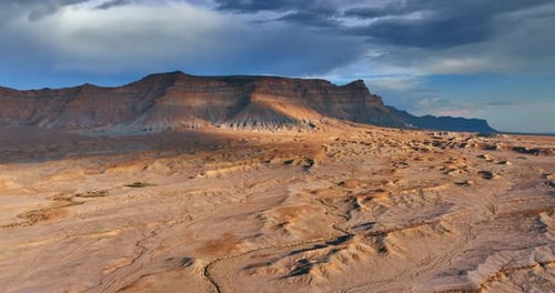 Stunning arid land and canyons. Drone flight over the desert and rocks under the grey sky.