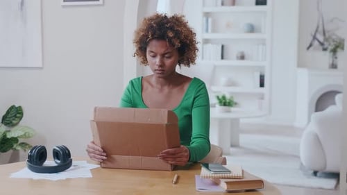 Woman Opening Package With a Confused Expression